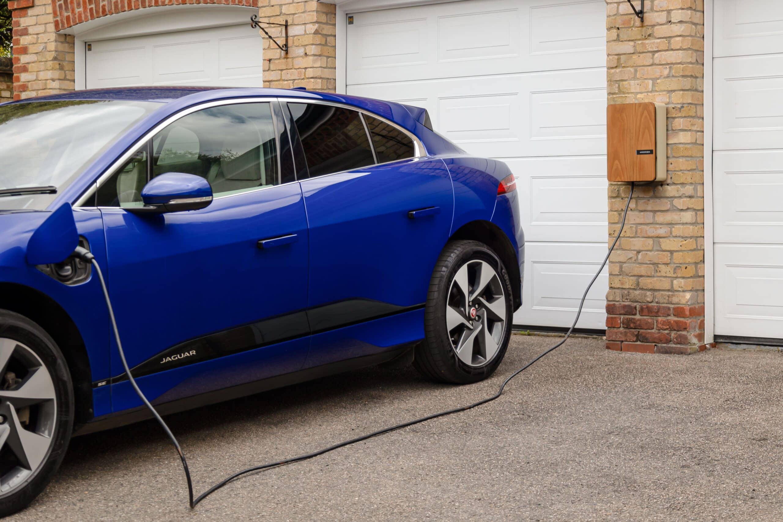 Vehículo eléctrico cargando en el garaje de una casa, representando la movilidad sostenible doméstica y la tecnología V2H.