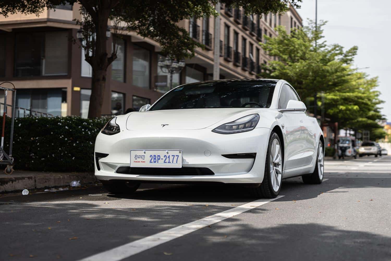 Coche eléctrico blanco moderno estacionado en una calle urbana, representando la estética de los vehículos eléctricos.
