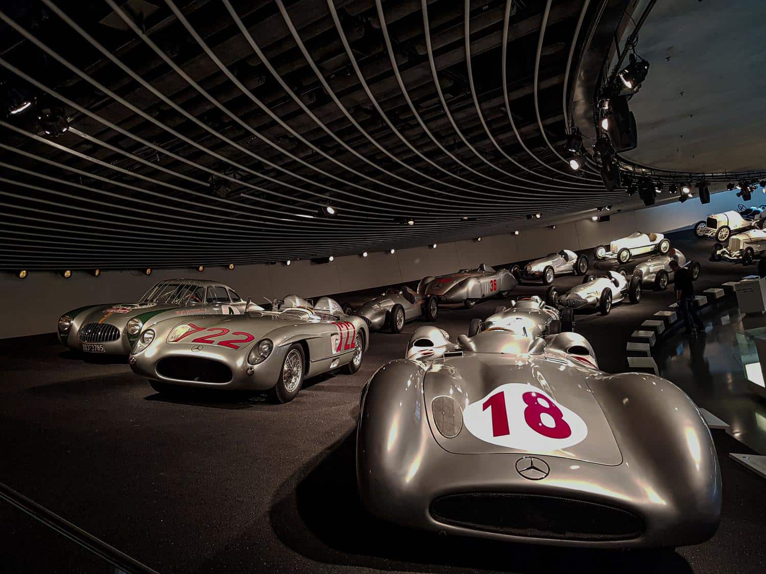 Coches de carreras clásicos 'Silver Arrows' en el Museo Mercedes-Benz, representando la sección de competición automovilística.
