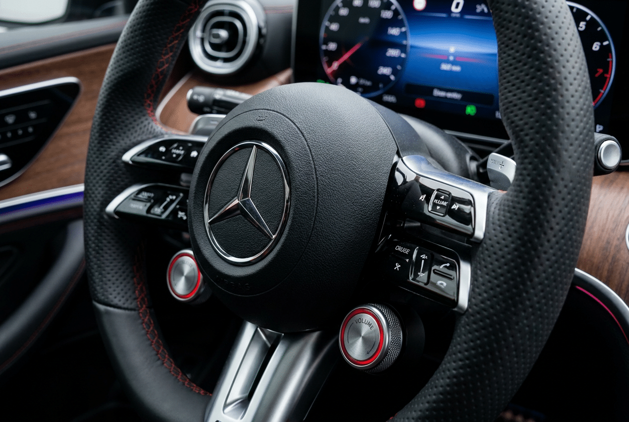 Primer plano del volante del Mercedes-Benz Clase C 2027 con el regreso de los mandos físicos mecánicos.