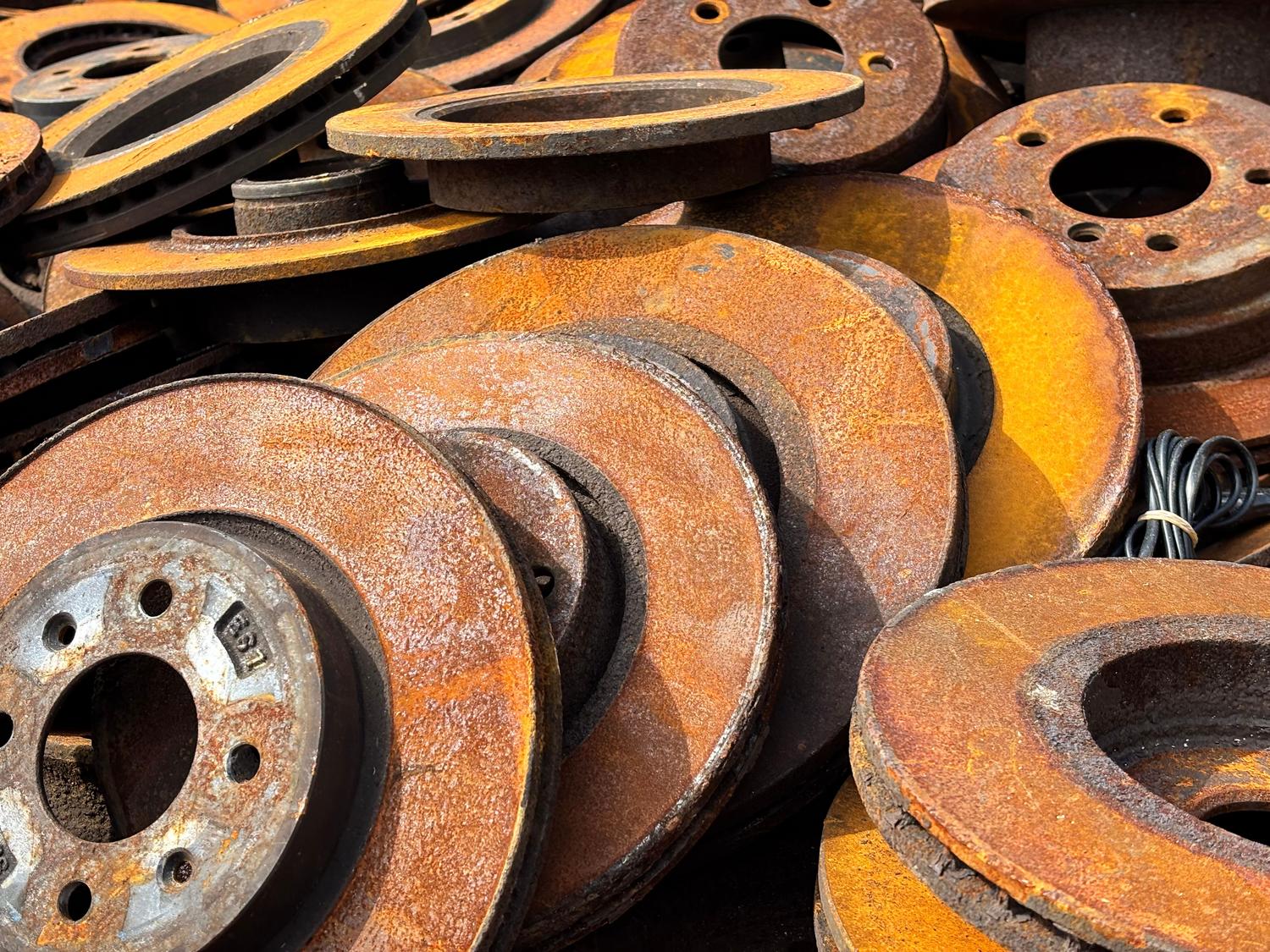 Primer plano de discos de freno oxidados, ilustrando el riesgo de corrosión por falta de uso en coches eléctricos.