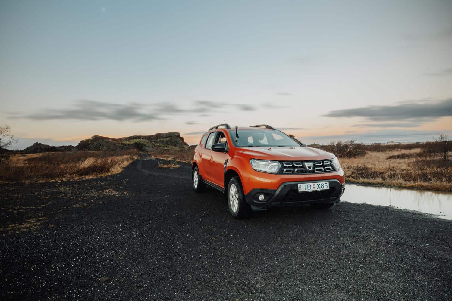 Dacia Duster naranja circulando por un camino rural, representando el vehículo basado en la plataforma CMF-B