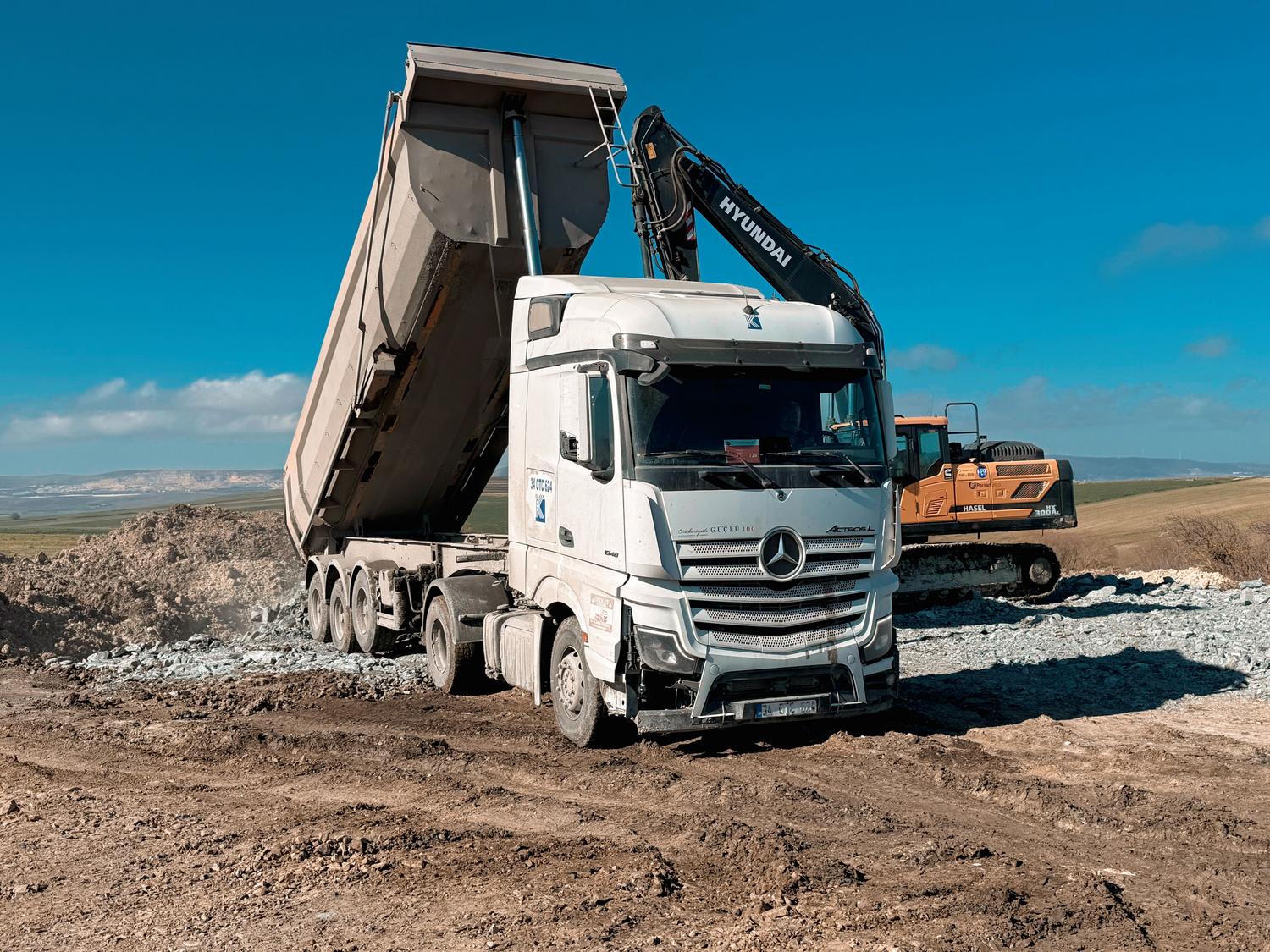 Camión volquete descargando materiales en una obra de construcción, ejemplo de vehículo robusto para obra pública