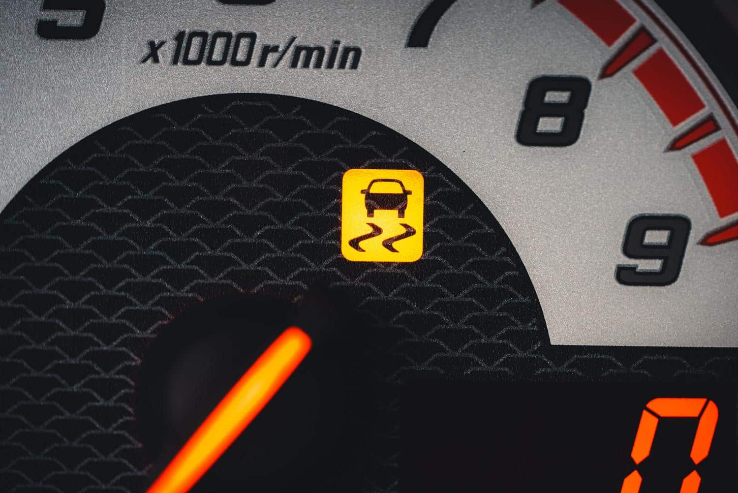Primer plano del testigo amarillo del control de estabilidad ESP encendido en el salpicadero de un coche.