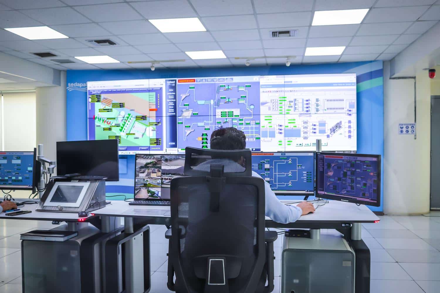 Centro de control tecnológico con múltiples pantallas, ilustrando la centralización de datos y la integración de APIs en la gestión de flotas.