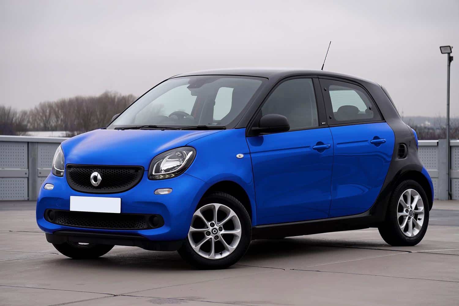 Coche eléctrico urbano compacto de color azul, ideal para ilustrar la disponibilidad de vehículos eléctricos asequibles y prácticos.