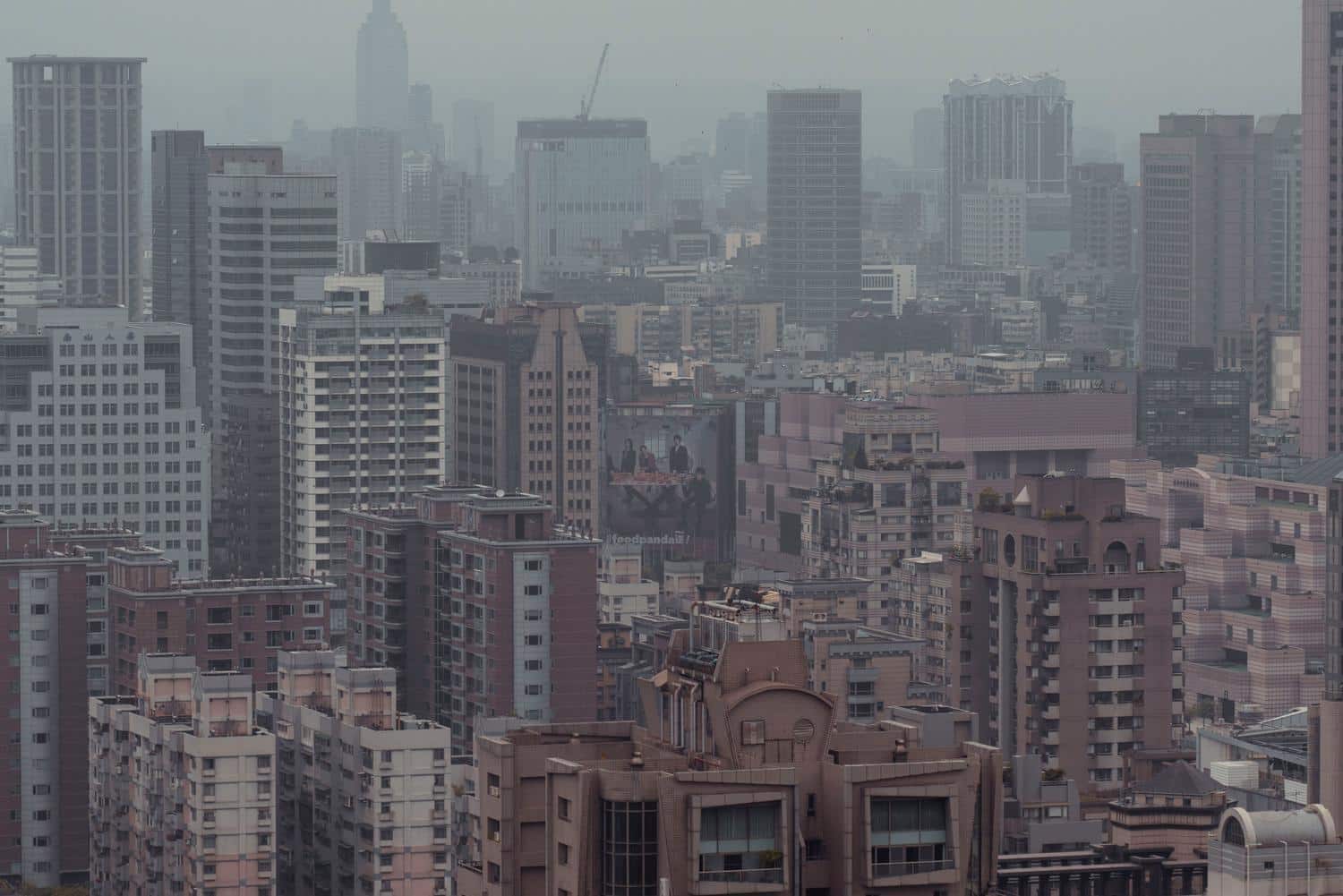 Vista aérea de un skyline urbano envuelto en smog y contaminación atmosférica, mostrando el problema ambiental que buscan combatir estas normativas.