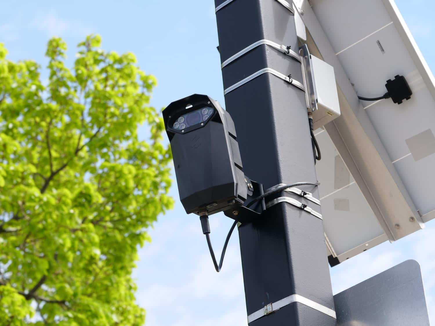 Cámara de seguridad moderna con panel solar instalada en un poste, reflejando el salto tecnológico en la monitorización vial.
